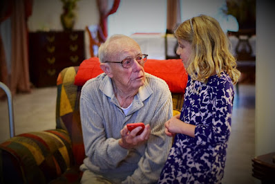 Girl showing older man how to use a phone