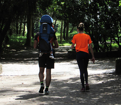 Casal caminhando com o filho nas costas