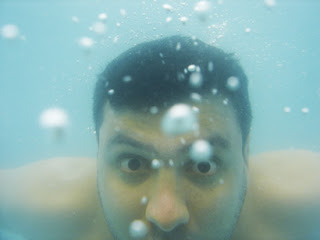 Rosto de um rapaz embaixo da água.