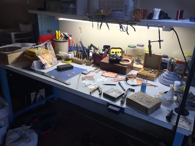 messy bench with metal and tools scattered around