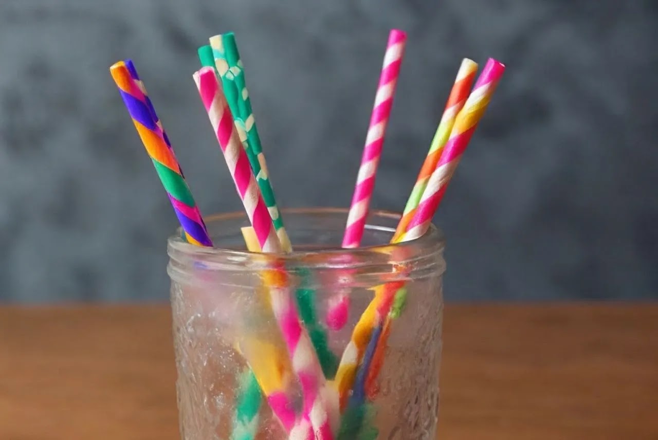 Colorful paper straws in a transparent glass