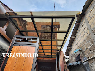 Pintu Pagar Besi Kombinasi Kayu dan Kanopi Besi Atap Solar Flat terpasang di Rumah Bu Dewi Pitara Depok