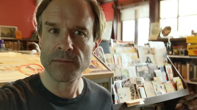 picture of a guy surrounded by vintage books