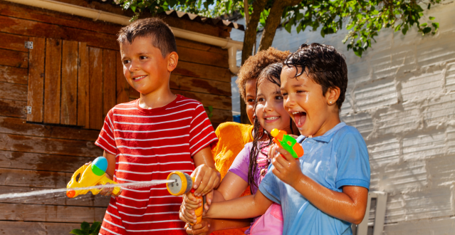 Kids enjoying summer by playing with water guns.