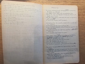 An open notebook of graph paper, filled with notes.
