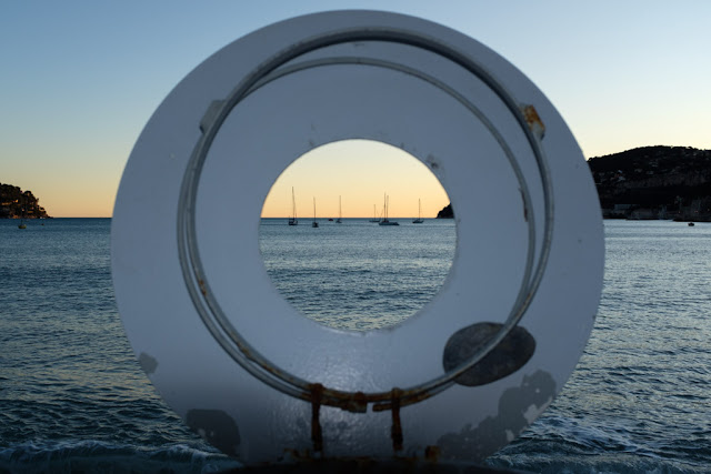 A view of the bay of Villefranche-sur-Mer through the hole in the lid of a garbage bin