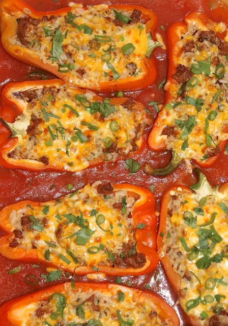 Baking dish of Chorizo and rice stuffed peppers with a spiced tomato sauce.