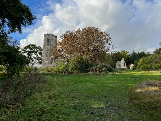 a stone tower in a grassy area