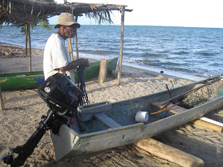 Belizean fisherman with outboard-powered dugout canoe