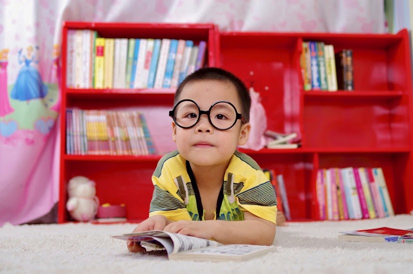 Niño leyendo con gafas