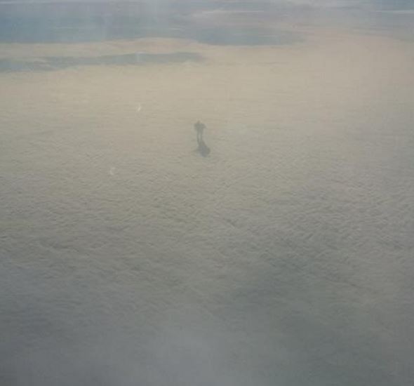 A plane passenger spotted a mysterious figure walking on the clouds 30,000 ft. above the ground.