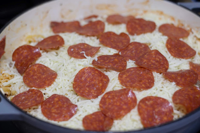 Slices of pepperoni over the top of the pasta dish. 