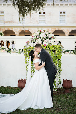 bride and groom kissing at altar