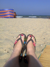 Feet in flip-flops on beach