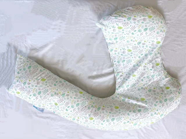 A dreamgenii pregnancy pillow on a bed