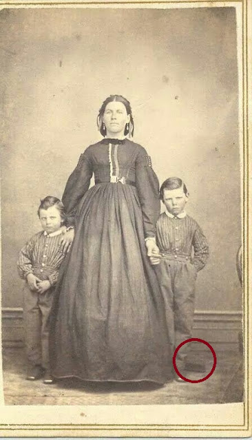 En la Imagen se puede observar en el niño de la derecha el aparato de sujeción. La mujer y el otro niño también están fallecidos.