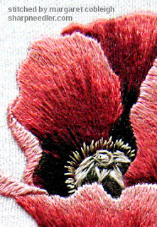 Close-up of thread paintined red poppy centre