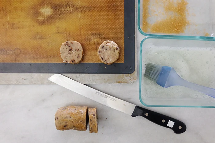 coating dough log in sugar and slicing