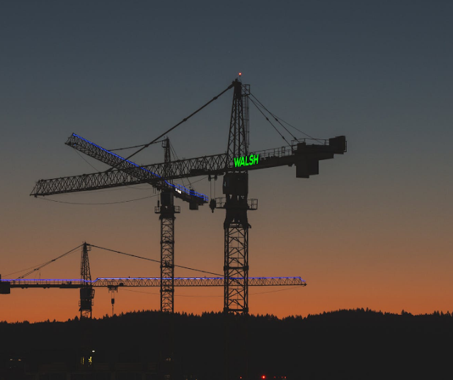 A crane carrying drilling machines at dusk