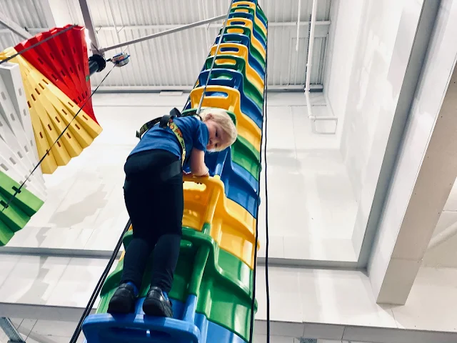 A bucket style climbing wall which is round and has steps with handles on directly above each other