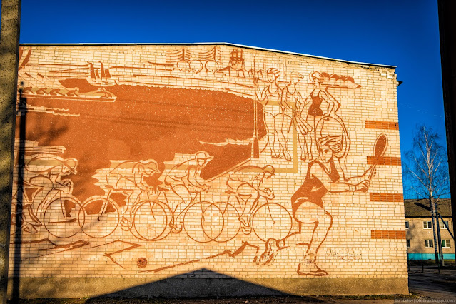 Рисунок тенесистки, велосипедистов и пловчих на кирпичной стене
