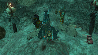 Link facing the camera in the Zonaite Armor and Hylian Hood, with the three sages behind him at a mine