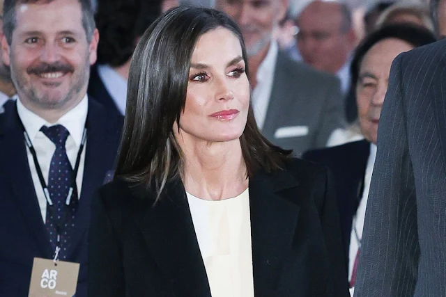 Queen Letizia wore a new white blouse by Adolfo Dominguez, and a black wool and cashmere blend coat by Carolina Herrera