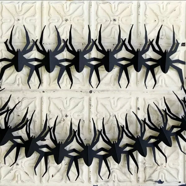 pair of papercut black spider garlands