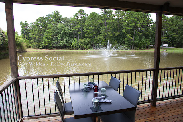 A table on the back porch of Cypress Social overlooks the lake and its fountain.