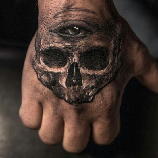 Cráneo con el tercer ojo tatuado en la mano