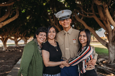 Marine posing with family for photo after graduation boot camp from MCRD SD