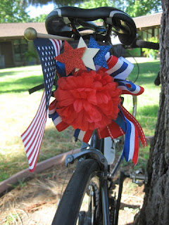 Bicycle saddle decorated with an American Flag and red, white, and blue ribbon, San Jose, California