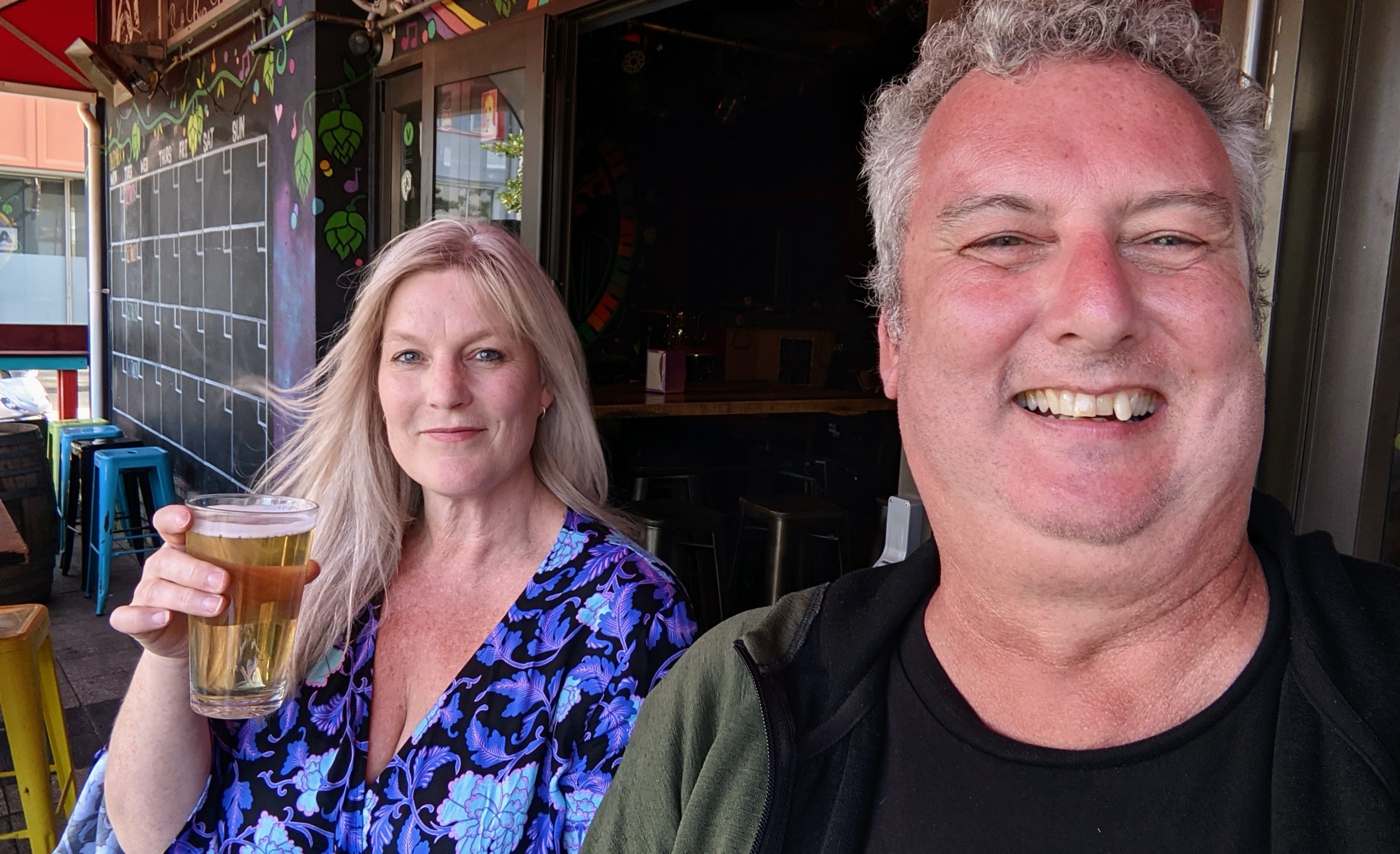 Selfie of two people having a drink at a bar