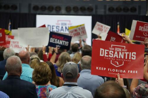 As Florida Gov. Ron DeSantis takes the stage in a packed college gymnasium in rural Columbia County on Nov. 3, 2022, rally attendees spring to their feet, cheering and waving campaign signs. (Nanette Holt/The Epoch Times)