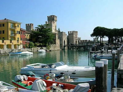 Castelul Scaligero din Sirmione, Brescia; cateva barci din portul aferent, inca o cladire si vegetatie