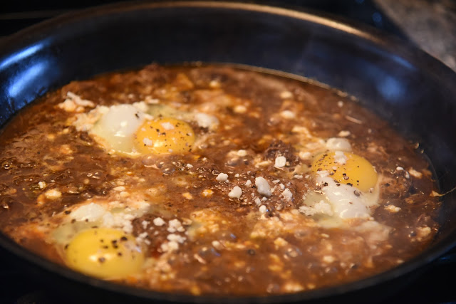 chipotle barbacoa reheated in a skillet, topped with eggs and cotija cheese