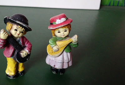 Miniatura de vinil de um casal de crianças tocando instrumento musical de corda  5,5cm R$ 15,00 os dois
