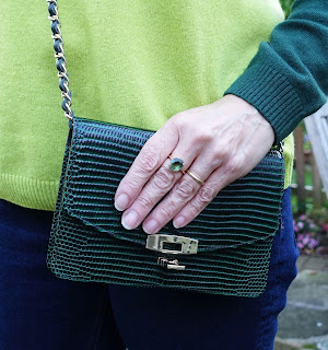 Image showing a compact cross-the-body bag in green leather by Uterque and peridot ring