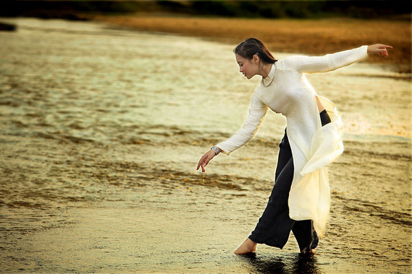 Thiếu nữ áo dài trắng đi trên suối