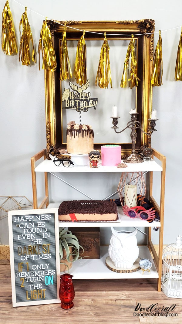 Set the scene for the perfect Harry Potter birthday party by gathering anything you've got that is Harry Potter themed. You can even hang a sweatshirt or hoodie as a backdrop. I've got a Harry Potter Funko Pop figurine, glasses, Luna Lovegood's glasses, a generic scarf (that is not actually the right colors).  Once you've source actual merchandise, look around for anything vintage...frames, mirrors, candelabras, bird cage, owls, candle holders, etc.  Then find anything gold; banners, buntings, glitter paper, etc.  Finally a letterboard or cinema marquee sign is the perfect way to drive the theme home.
