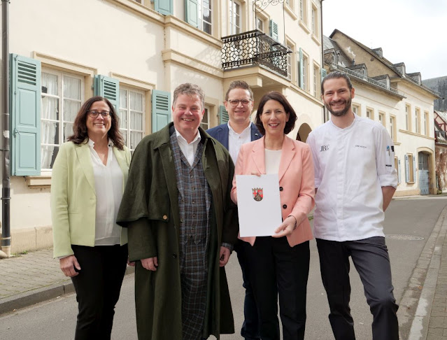 Wirtschaftsministerin Daniela Schmitt übergibt vor dem "Fürstenwärther Hof" den Förderbescheid an (von rechts) Erik Koch, Markus Pape und Professor Christian Held, allesamt Gesellschafter der Meisenheimer Hof GmbH und Co. KG.