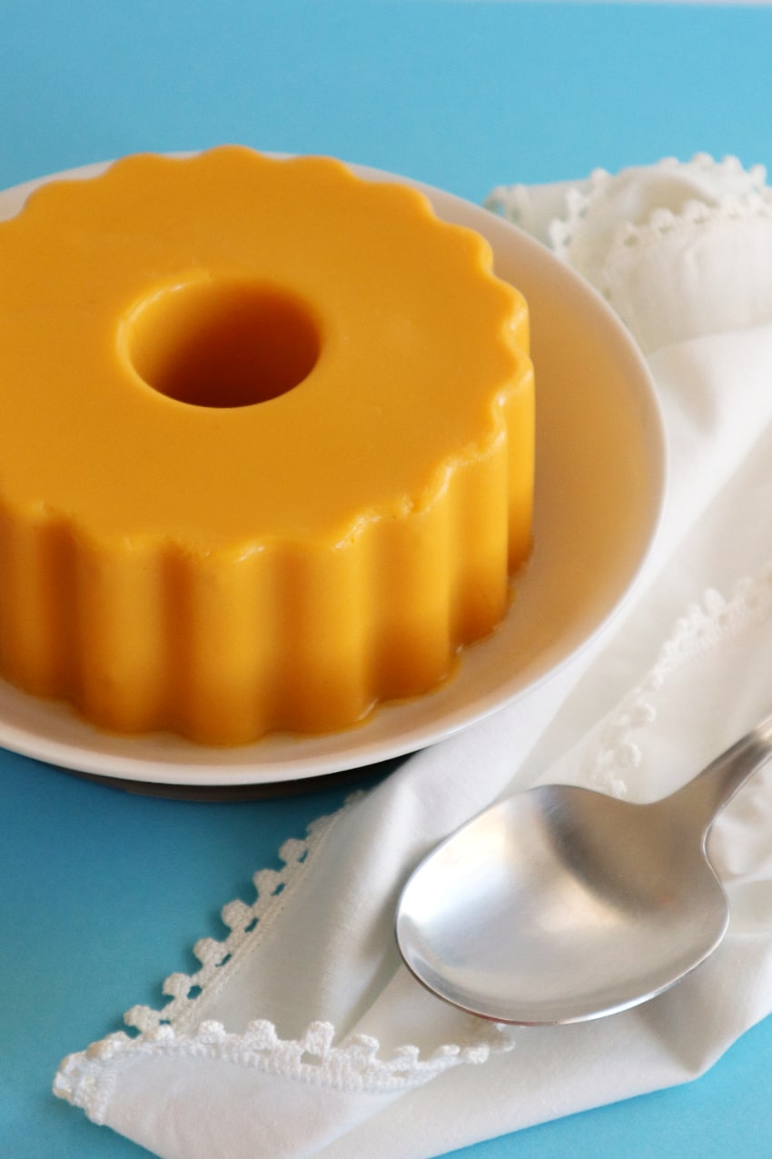 mango pineapple pudding on a plate along with a serving spoon