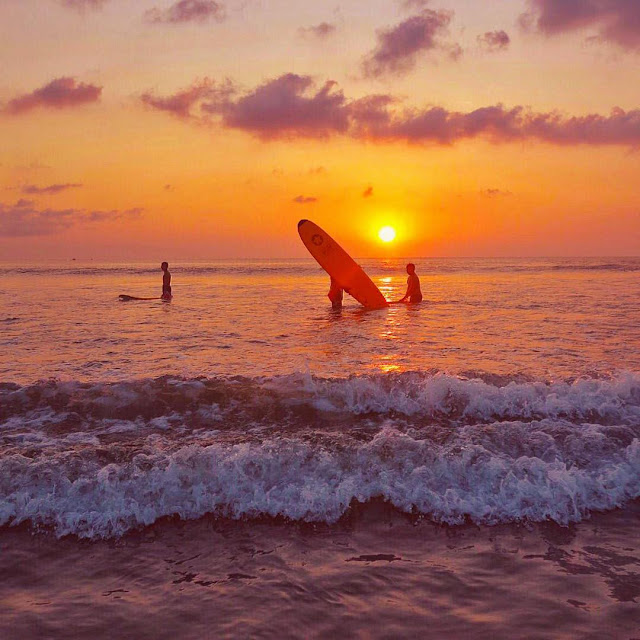 Surfing Dengan Latar Belakang Sunset Di Pantai Kuta