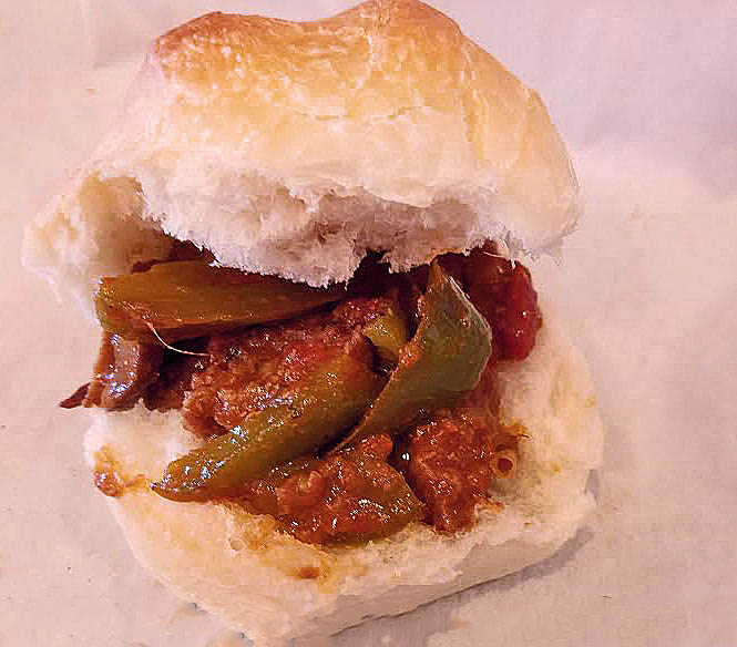 this is an Italian sandwich with sausage, peppers, onions and mushrooms in a cabernet sauce