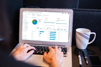 Doing online business on a computer with a mug of beverage on the table.