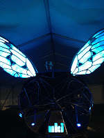 Steampunk bug with glowing wings and a DJ in a top hat on top of it