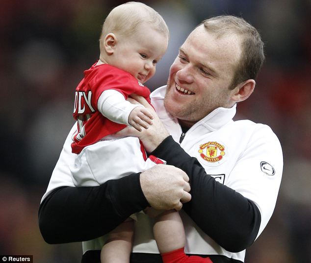 That's my boy Delighted Wayne Rooney holds his son Kai aloft at Old 