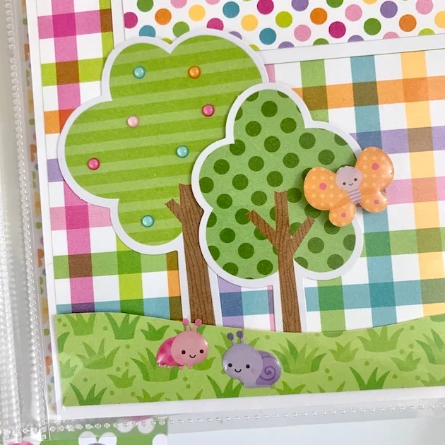 8x8 Spring scrapbook pages with a cute enamel butterfly, ladybug, snail, and trees with little colorful dots
