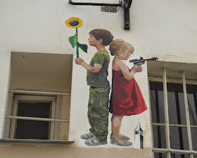 Paris street art graffiti child with gun child with sunflower