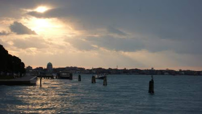 Image of the main Island of Venice, at Dawn, looking out at columns (wooden piles) in the water.